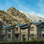 Traditional stone house in Andorra with mountain backdrop.