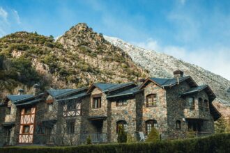 Traditional stone house in Andorra with mountain backdrop.