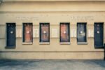 Row of closed ticket booths at an attraction venue, with numbered windows and accessibility signage