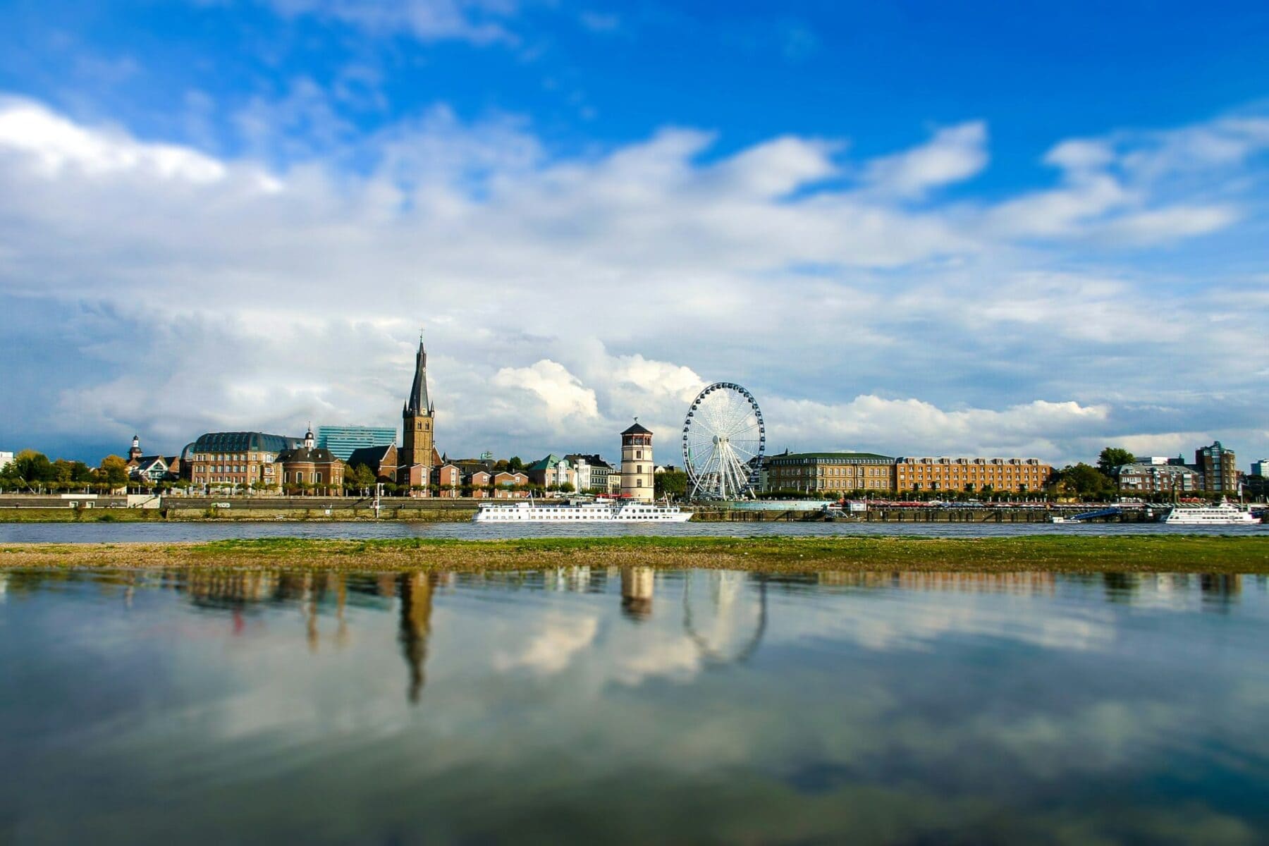 Düsseldorf skyline with Ferris wheel and Rhine promenade reflected in the river