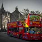 City Sightseeing tour bus driving past historic buildings in Edinburgh, Scotland
