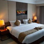 Modern hotel room with a large double bed, bedside lamps, and contemporary decor, ideal for illustrating global hotel group apps.
