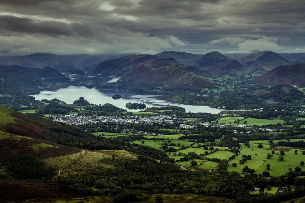 Scenic view of the Lake District with mountains, green fields, and lakes, representing countryside destinations in the United Kingdom travel guide.