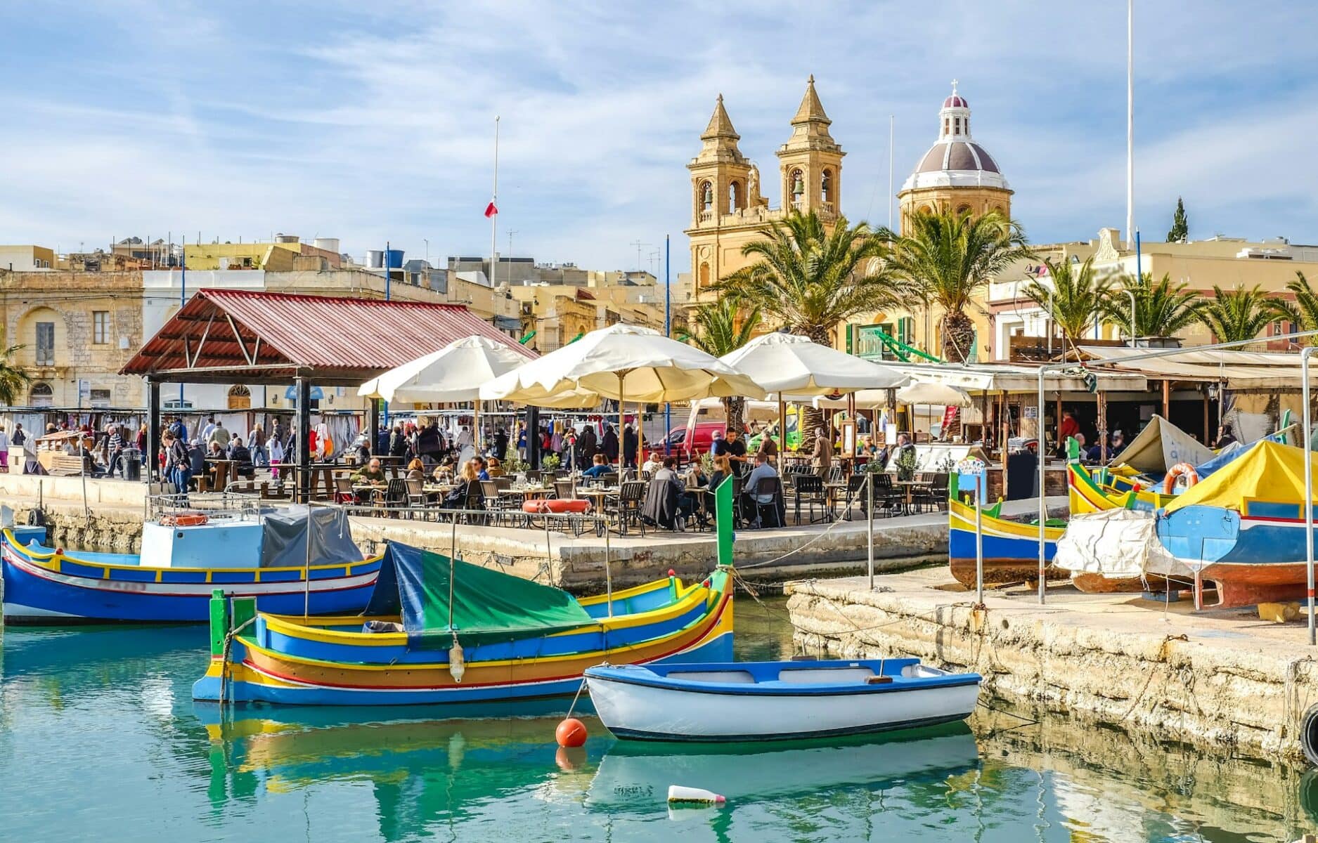 Colourful fishing boats and market stalls in Marsaxlokk, Malta