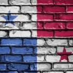 Panama flag design painted on weathered brick wall with blue, white, and red sections and stars