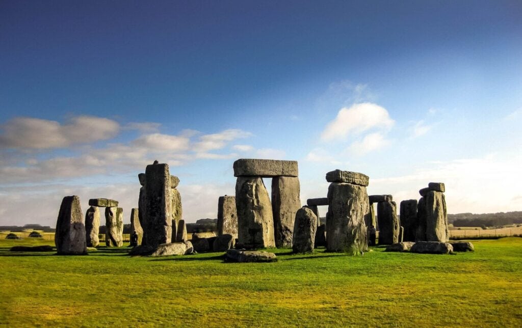 Stonehenge standing stones under a bright blue sky, symbolising heritage attractions featured in the United Kingdom travel guide.