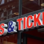 Close-up of a "Tours & Tickets" sign outside a travel booking office, representing tour booking and attraction ticket services.