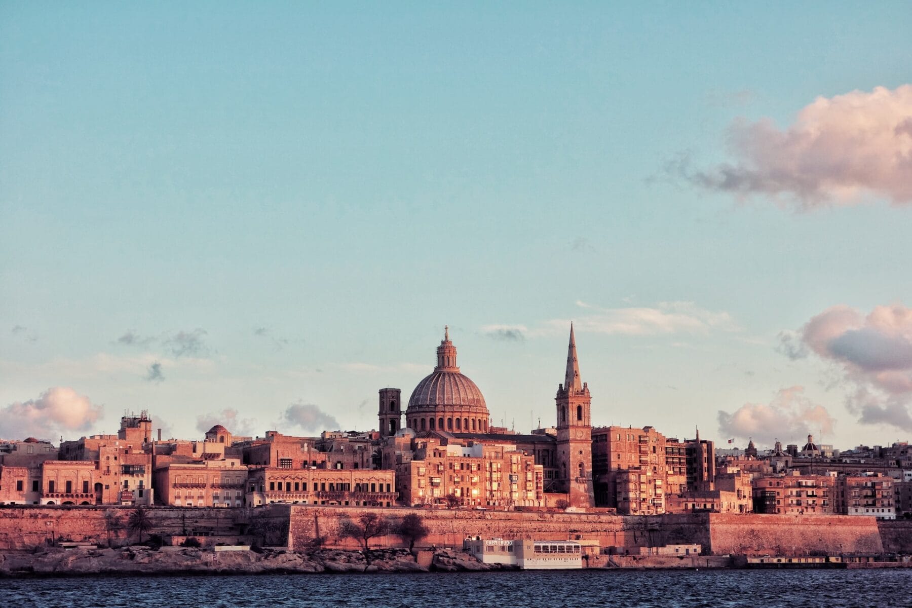 Valletta skyline with St Paul’s Cathedral dome and spire at sunset, Malta