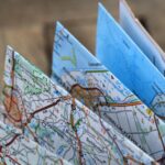 Folded paper maps displaying detailed road networks, place names, and numbered routes with Dutch location names visible