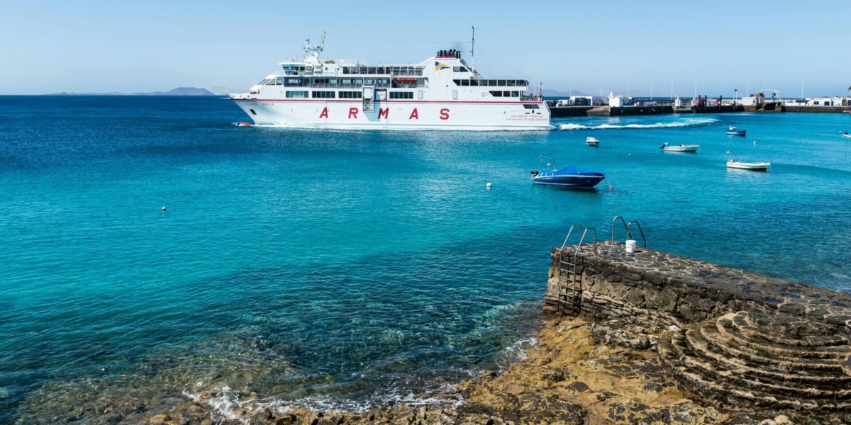 Ferry from Armas sailing in the Balearic Islands, Spain with clear turquoise waters and small boats nearby