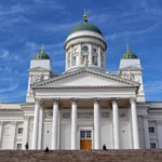 White Helsinki Cathedral with green domes against a vivid blue sky