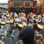 Drummers in colourful costumes leading the Manchester Day parade along Deansgate.