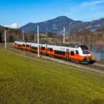 ÖBB regional train crossing the Austrian countryside with mountains in the background