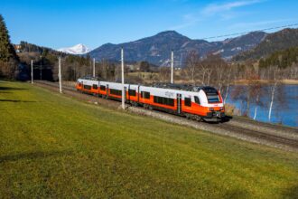 ÖBB regional train crossing the Austrian countryside with mountains in the background