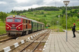 Red BDZ diesel train at a small Bulgarian station.