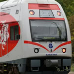 Lithuanian Railways train with red and white livery heading to Palemonas.