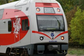 Lithuanian Railways train with red and white livery heading to Palemonas.