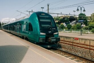 Green Vy train at Sandefjord station in Norway.