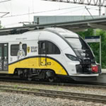 Yellow and white Koleje Dolnośląskie regional train in Poland.