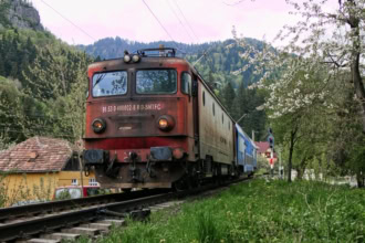 CFR train running through Romaniaโs Carpathian Mountains.