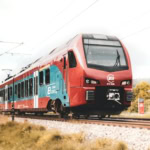 Red and blue Srbija Voz train on rural Serbian tracks.