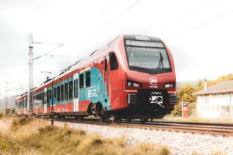 Red and blue Srbija Voz train on rural Serbian tracks.