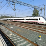 White Renfe long-distance train at a station in Spain.