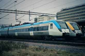 Two Vรคsttรฅgen regional trains at a Swedish city station.