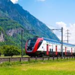 Swiss SBB double-decker train with Alps in the background.