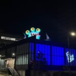 Colourful monster installation on a Manchester rooftop glowing at night during Halloween in the City.