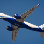 IndiGo aircraft climbing against a clear blue sky