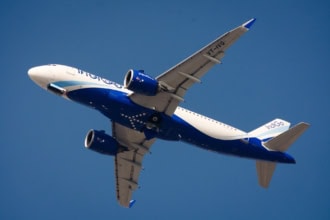 IndiGo aircraft climbing against a clear blue sky