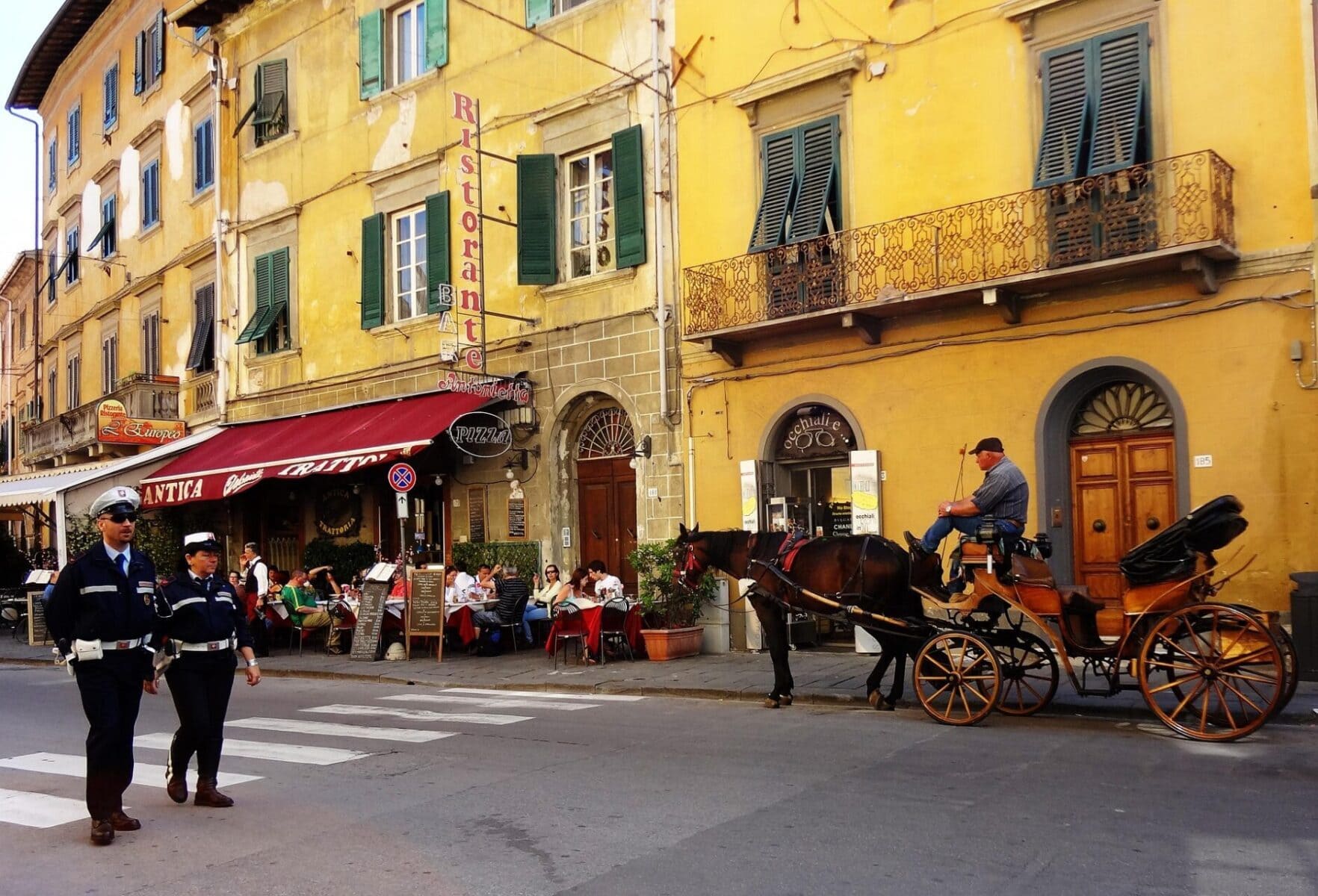 Traditional horse carriage and café scene in Pisa’s historic centre, Italy