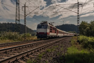 Intercity train crossing the Slovak countryside under electric wires