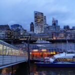 Uber Boat by Thames Clippers vessel docked at Tower Pier with London skyline at dusk