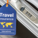 Blue luggage tag reading “Travel Insurance International” attached to a silver suitcase