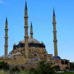 Exterior of the Selimiye Mosque in Edirne with four tall minarets against a clear blue sky.