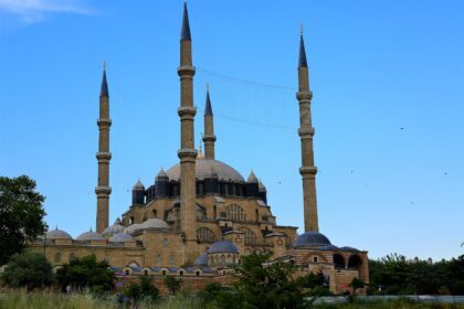 Exterior of the Selimiye Mosque in Edirne with four tall minarets against a clear blue sky.