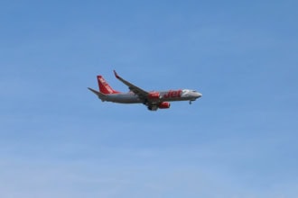 Jet2 aircraft flying in clear blue sky above clouds