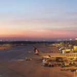 Manchester Airport Terminal 2 apron at sunset with Qatar Airways aircraft parked at gates