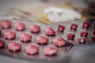 Blister packs of pink prescription tablets on a table