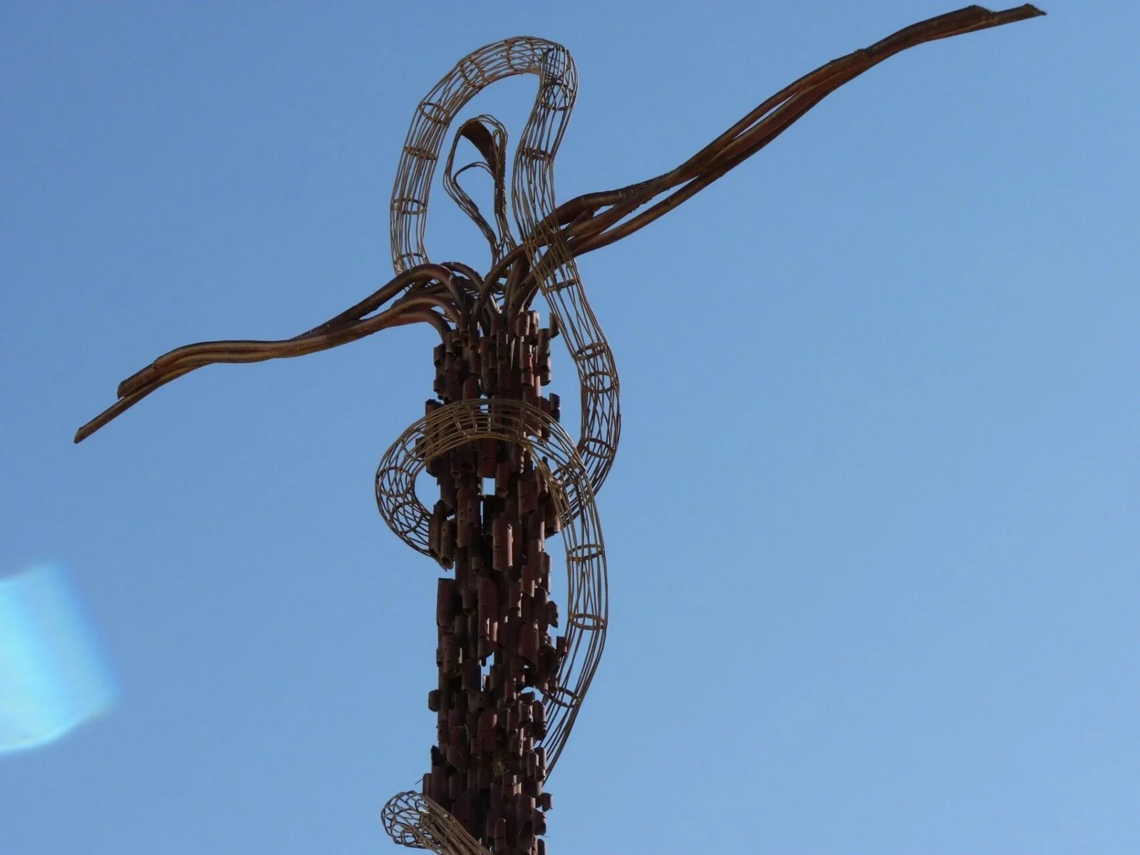 erpentine Cross sculpture at Mount Nebo in Jordan against a clear blue sky.
