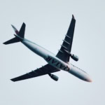 Qatar Airways aircraft flying overhead in clear sky