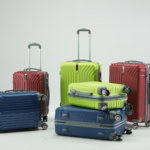 Hard-shell suitcases in blue, red, and lime green arranged together, showing different sizes of carry-on and cabin luggage.