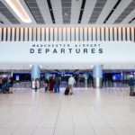 Manchester Airport departures hall with check-in desks and passengers