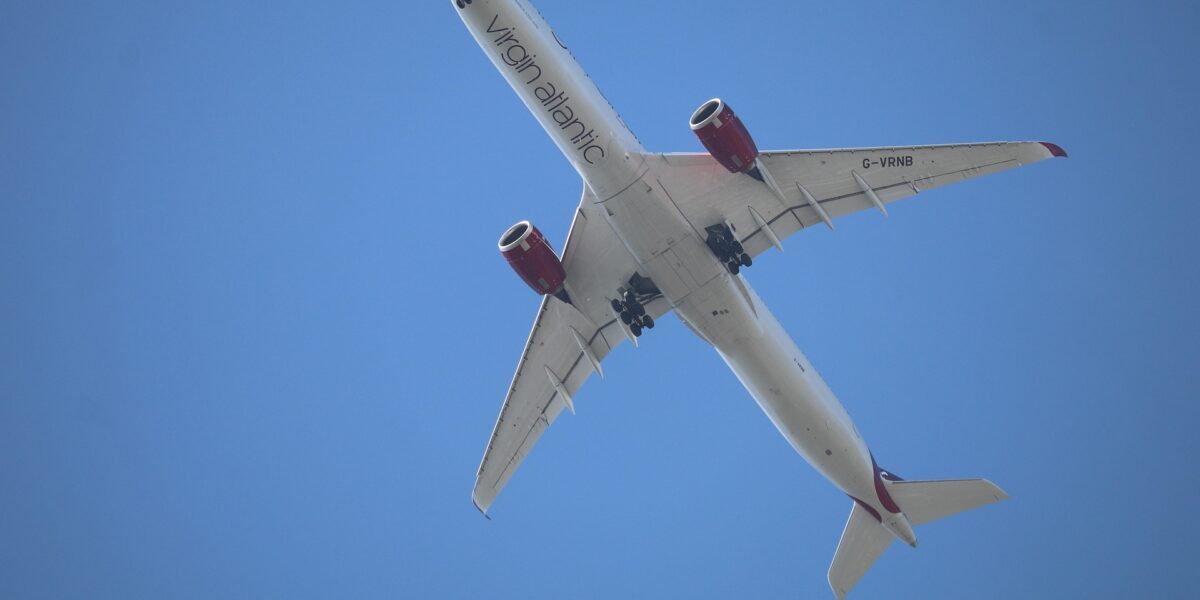 Virgin Atlantic aircraft flying overhead against a clear blue sky