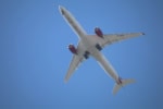 Virgin Atlantic aircraft flying overhead against a clear blue sky