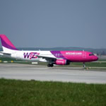 Wizz Air Airbus A320 aircraft in pink and white livery on an airport runway
