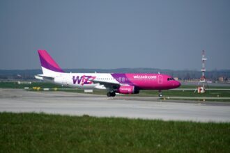 Wizz Air Airbus A320 aircraft in pink and white livery on an airport runway