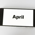 April travel planning concept showing the word April on a smartphone screen